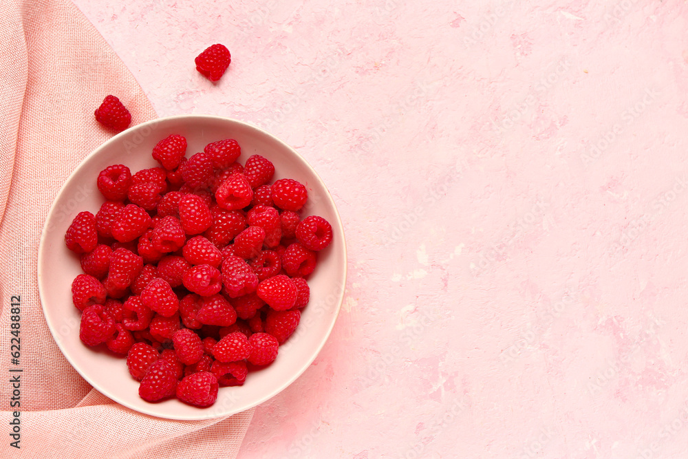 Bowl with fresh raspberries on pink background Bowl with fresh raspberries on pink background