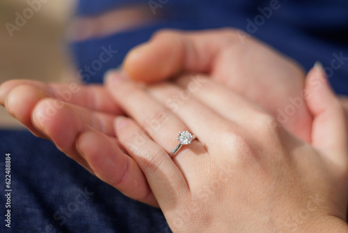 婚約指輪を付けたカップルの手