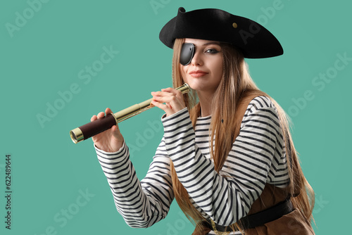 Konstfotografi Beautiful female pirate with spyglass on green background