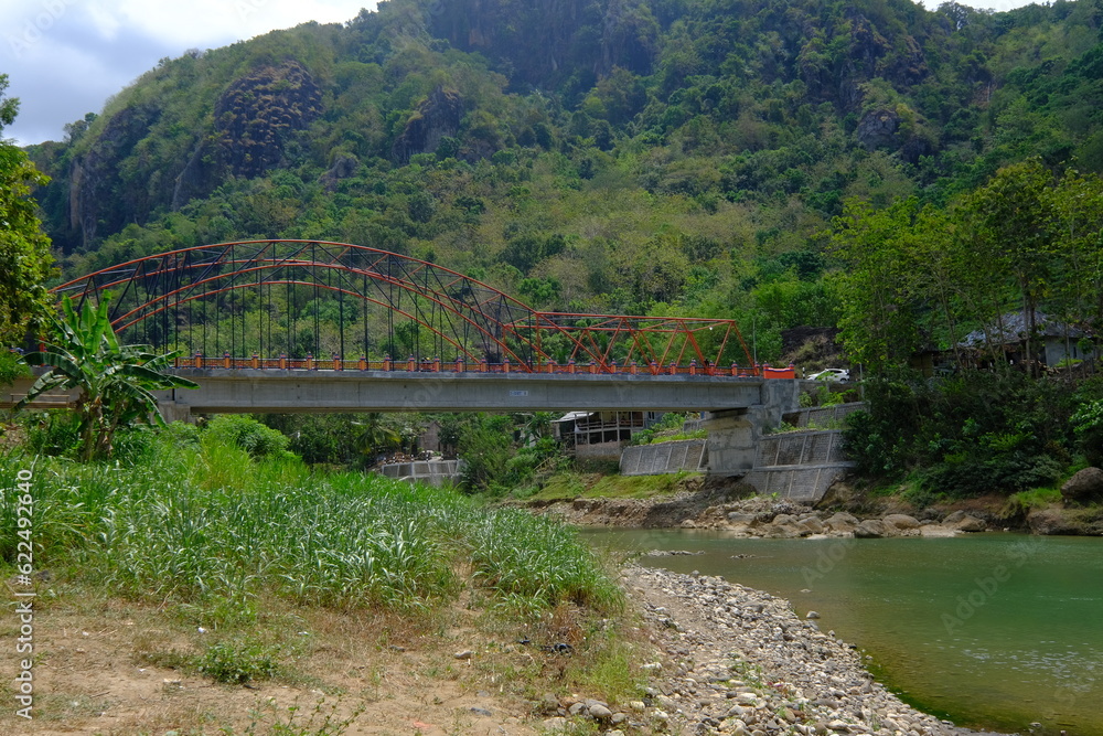 steel bridge over rocky river. tropical green mountains. steel bridge over rocky river. tropical green mountains.