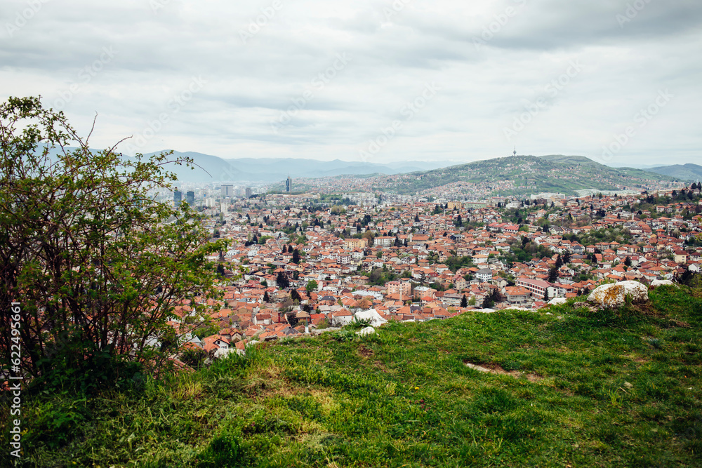 Panoramic view of the spring city of Sarajevo, Bosnia and Herzegovina from green view point. A trip to a European city in the mountains with orange roofs