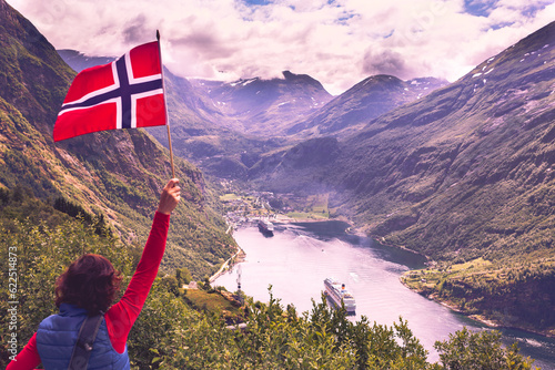 Tourist over Geirangerfjord with norwegian flag photo