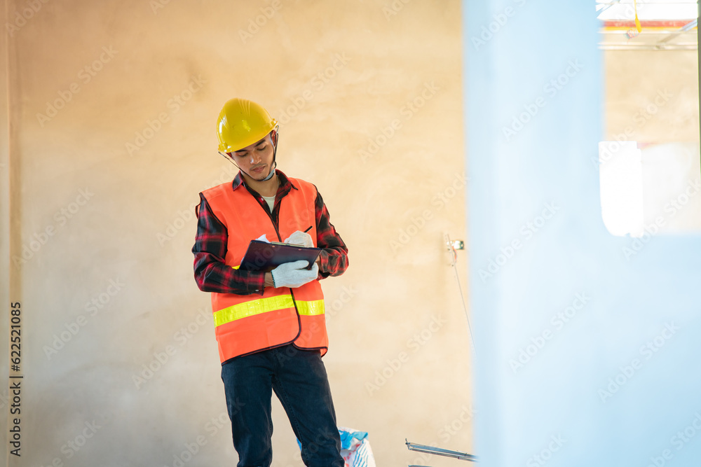 Young engineer in charge of building construction checking his tablet device Young engineer in charge of building construction checking his tablet device