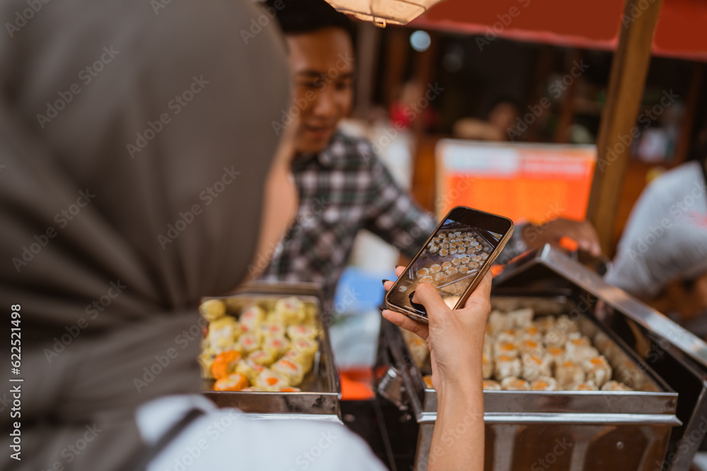 man sells various kinds of dumpling food with a cart on the side of the road