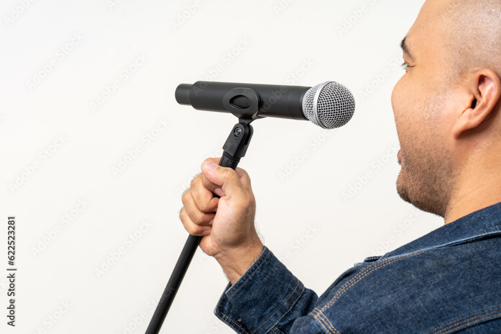 Close up male hand holding High quality dynamic microphone and singing song or speaking talking with people on isolated white background. Male testing microphone voice for interview Close up male hand holding High quality dynamic microphone and singing song or speaking talking with people on isolated white background. Male testing microphone voice for interview