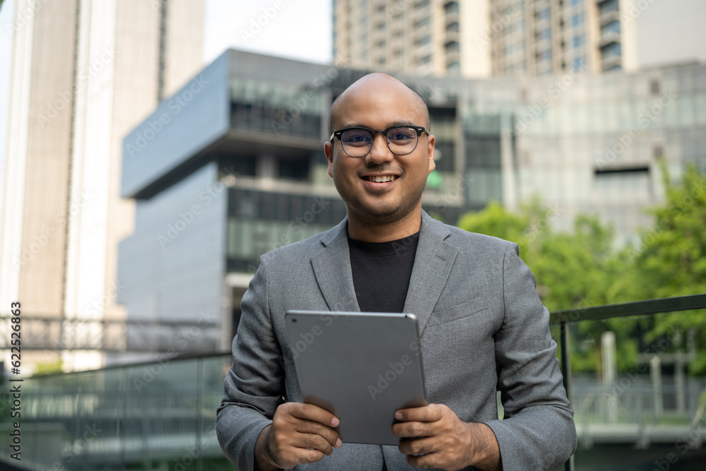 Senior manager business man in suit with tablet at the buildings downtown. Confident man using digital tablet looking towards their goals for success. Executive business man Senior manager business man in suit with tablet at the buildings downtown. Confident man using digital tablet looking towards their goals for success. Executive business man