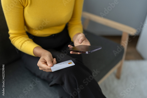 Asian businesswoman shopping online on mobile with credit card for convenient spending at home on vacation, online banking banking, e commerce virtual shopping, secure mobile banking concept.