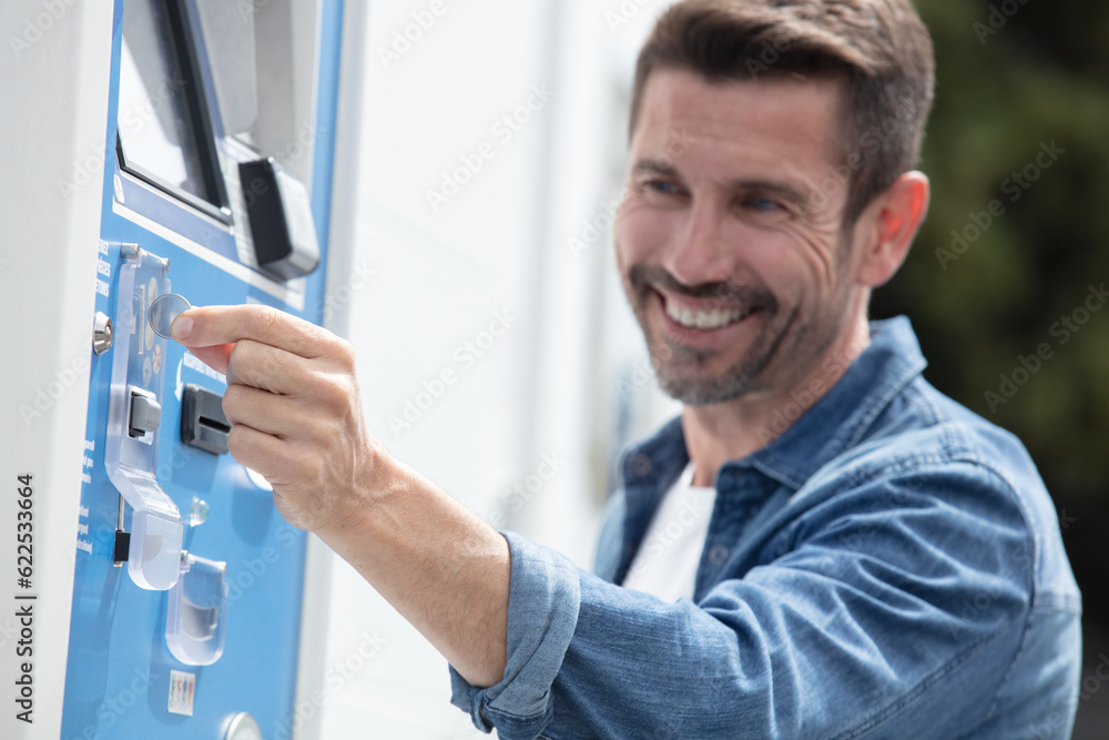 Fototapeta premium a happy man paying at parking meter