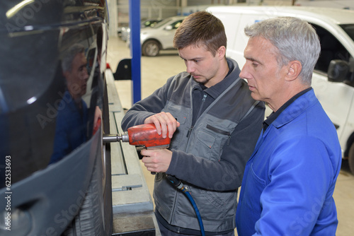 student with instructor repairing a car during apprenticeship