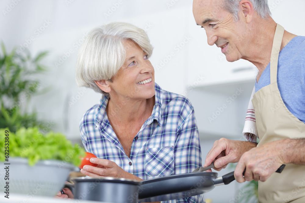 a mature couple cooking together a mature couple cooking together