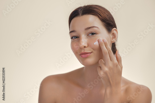 Face Skin Care Concept With Woman Applying Cosmetic Cream on Clean Hydrated Skin