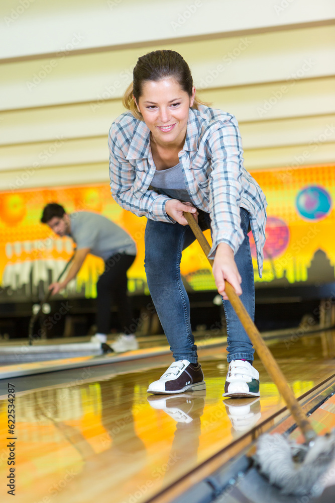 woman cleaning bowling alley lane
