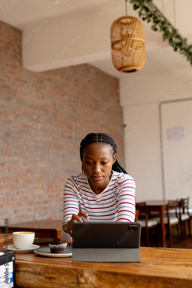 African american woman using tablet in a cafe, copy space African american woman using tablet in a cafe, copy space