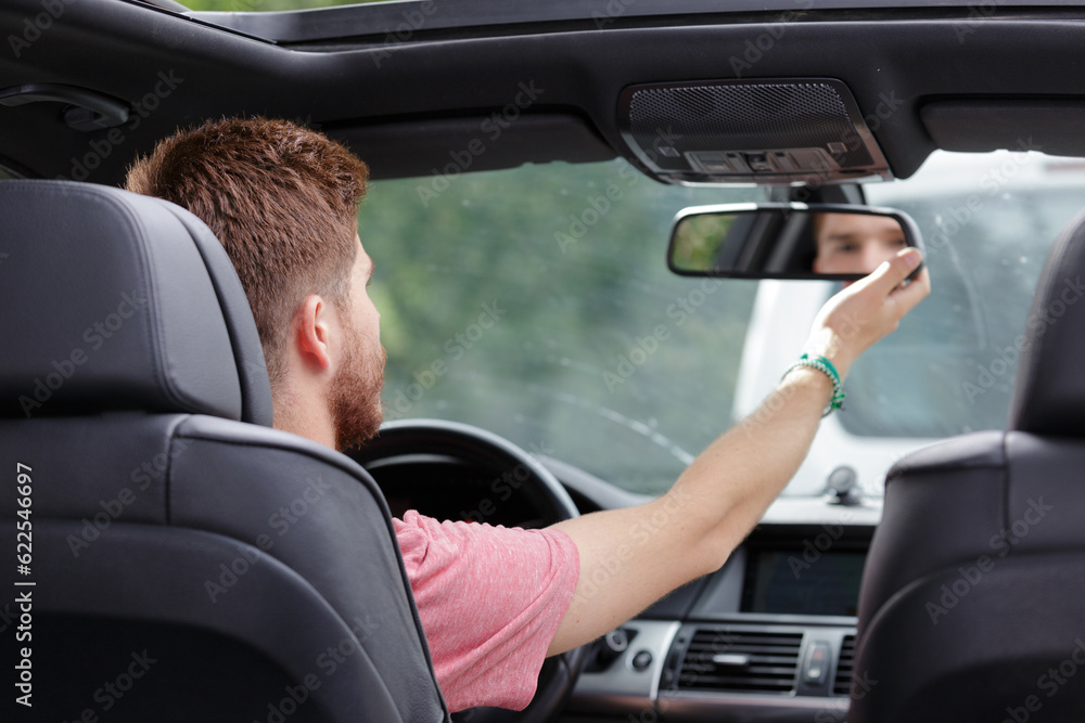 man checking his car mirror man checking his car mirror