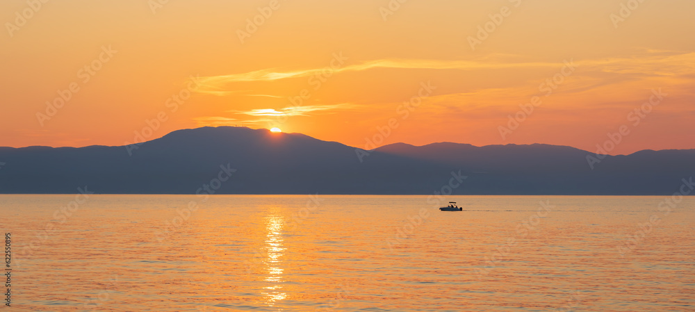 Small boat silhouette float on sea with sunset sky and distant hill. Travel, sport background, Croatia, island Krk