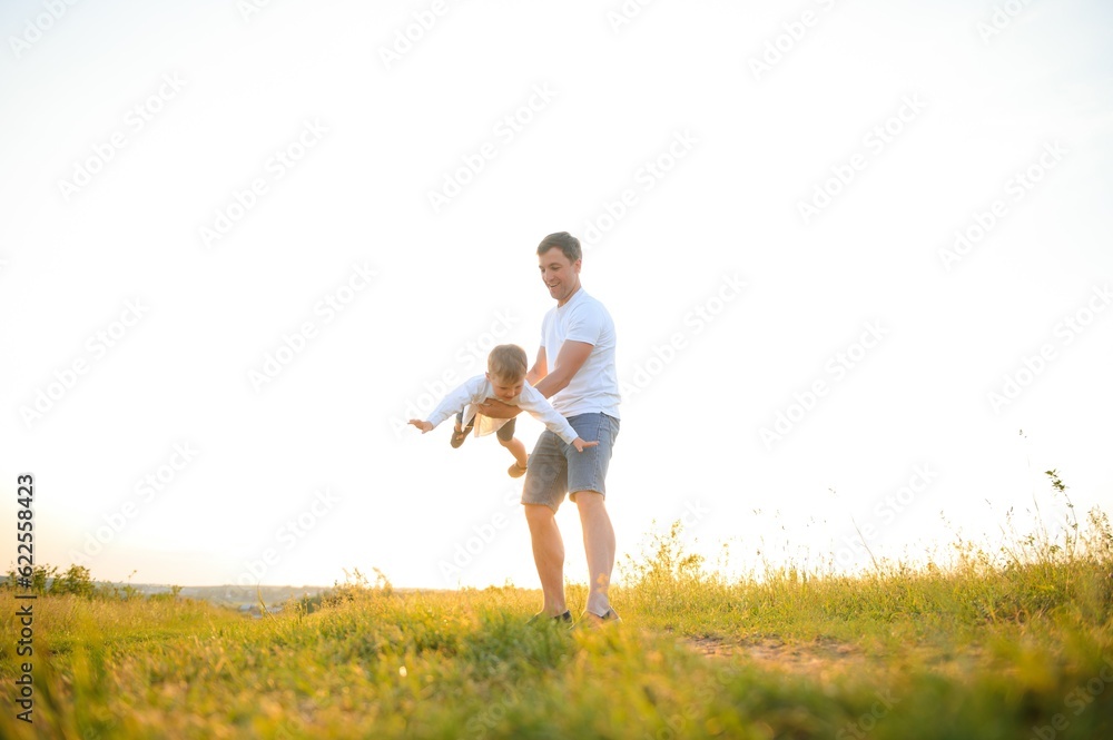 Happy father, son child running playing in the park outdoors together. Family, Father's Day, parenting, active lifestyle concept. Happy father, son child running playing in the park outdoors together. Family, Father's Day, parenting, active lifestyle concept.