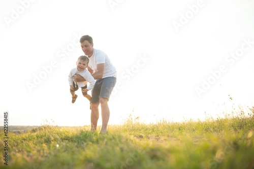 Father s day. Happy family father and toddler son playing and laughing on nature at sunset
