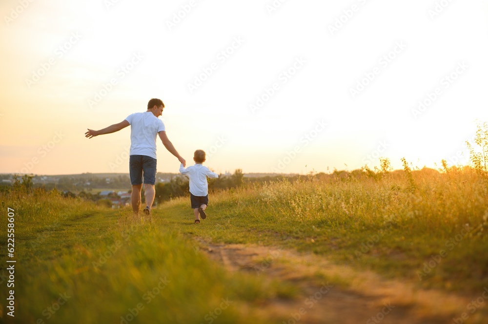 father's day. Dad and son playing together outdoors on a summer. Happy family, father, son at sunset.