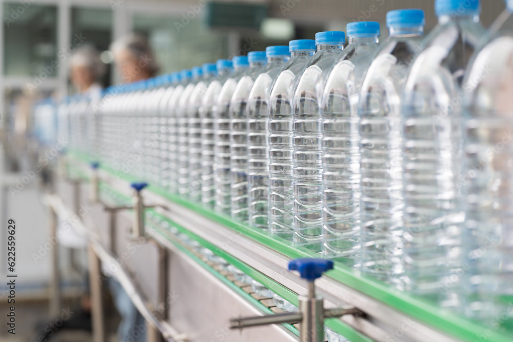 Clean purified drinking plastic bottled water inside automated conveyor belt production line in drinking water factory