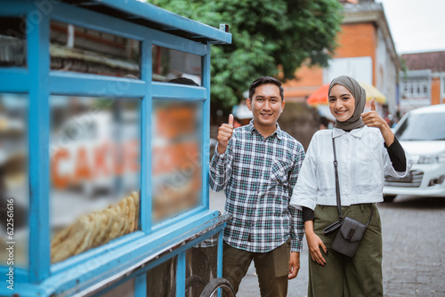 portrait of muslim couple shopping on street food vendor © Odua Images