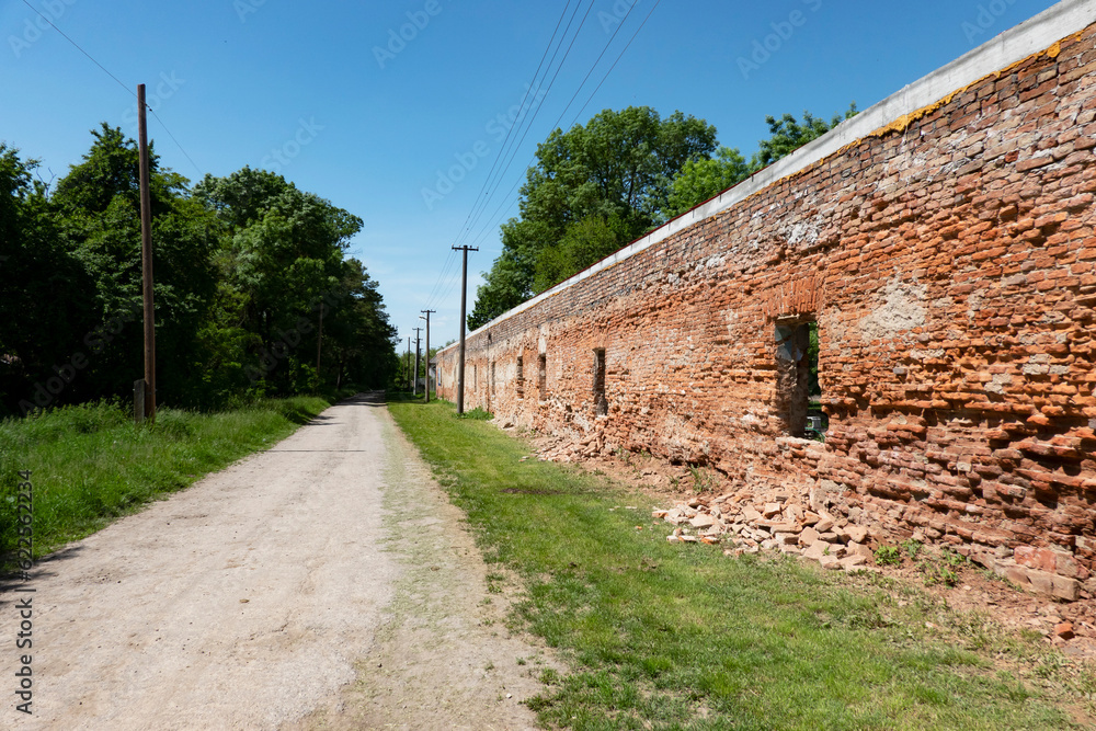 A road leading past a brick wall