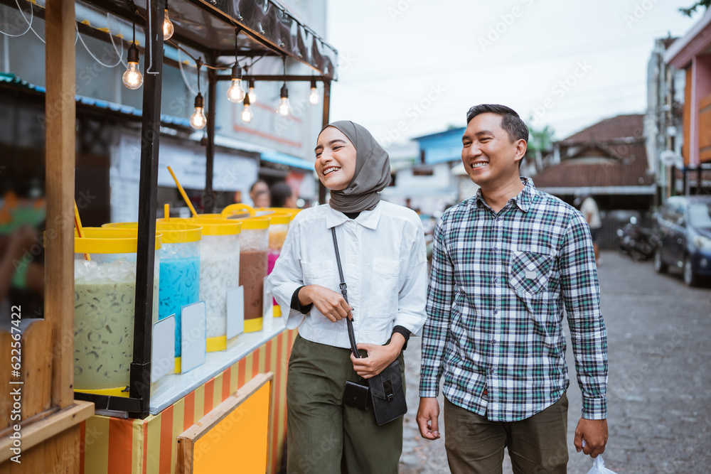 beautiful muslim couple are shopping in a food stall or street vendor during ramadan beautiful muslim couple are shopping in a food stall or street vendor during ramadan