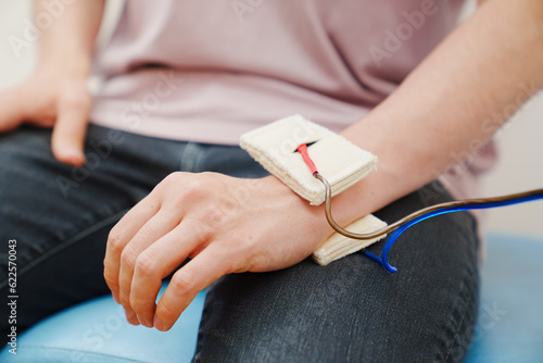patient with an electrotherapy on hand. electrical stimulation. photo