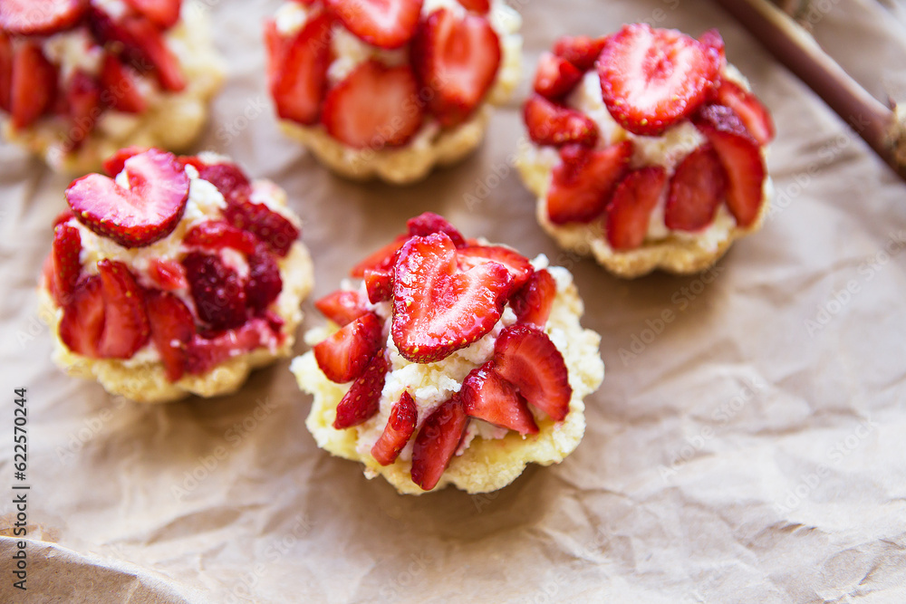 Very tasty muffins with fresh strawberries lie on kraft paper Very tasty muffins with fresh strawberries lie on kraft paper