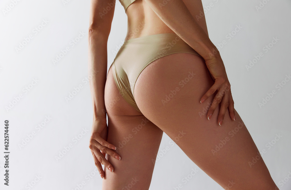 Cropped image of female body, buttocks in underwear against grey studio background. Anti-cellulite care, massage, spa. Concept of female beauty, body care, fitness, sport, health, figure, ad