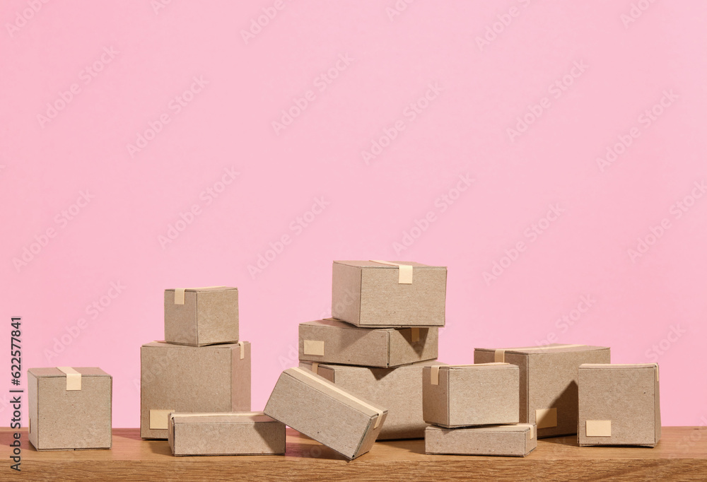 Packed and sealed cardboard boxes different sizes lie on a wooden table. Idea of relocation. Copy space for text. Packed and sealed cardboard boxes different sizes lie on a wooden table. Idea of relocation. Copy space for text.