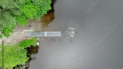 Aerial overhead video of black lab jumping from a dock and into a pond chasing a stick Burrillville, RI photo
