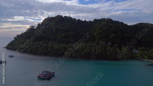 Stunning aerial top view flight 
Boats anchoring in sea, island Ko Kut Ao Phrao beach, Thailand 2022. descending drone
4K Cinematic. photo