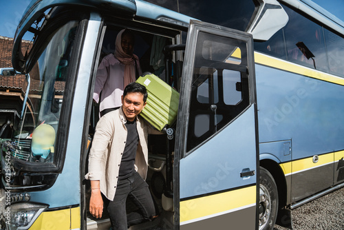 happy asian muslim passengers lined up in line to get off the bus