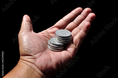 Coins on the palm of the hand on a black background