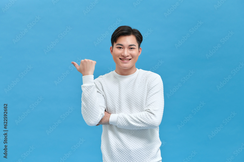 man smiling with happy face looking and pointing to the side with thumb up. man smiling with happy face looking and pointing to the side with thumb up.