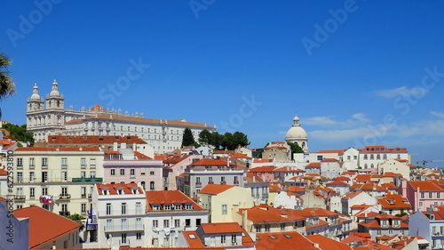 schöner Aussichtspunkt "Miradouro de Santa Luzia" in Lissabon mit weißen Häusern, roten Dächern, Kirchen, Meer und Sonne