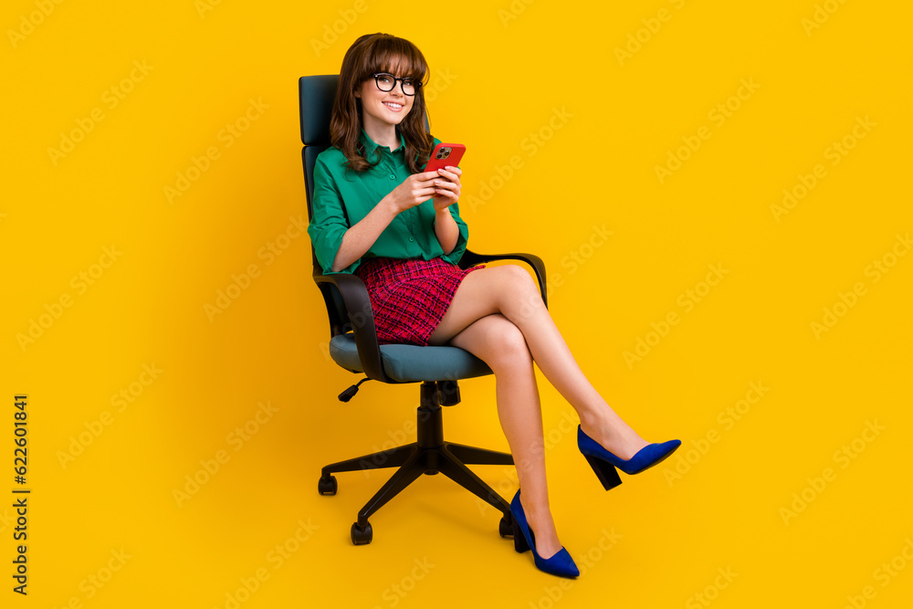 Full length photo of pretty cute lady wear green shirt texting sms instagram twitter telegram facebook isolated yellow color background Full length photo of pretty cute lady wear green shirt texting sms instagram twitter telegram facebook isolated yellow color background
