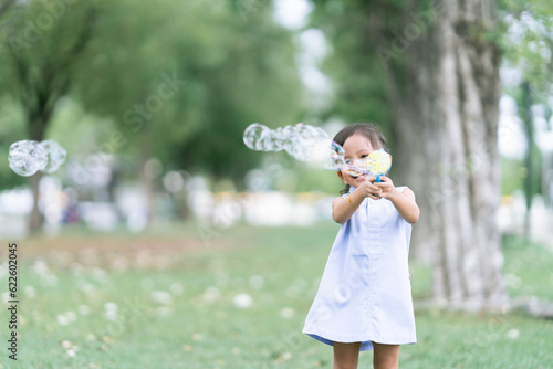 Asian children Shooting Bubbles from Bubble Gun in the park