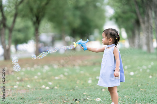 Asian children Shooting Bubbles from Bubble Gun in the park