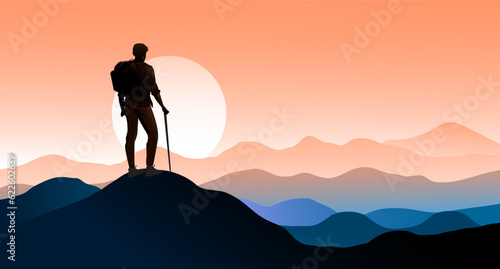 Backpacker on mountain top. Male person with backpack standing on top looking at view over horizon, mountain range and sunset or sunrise.