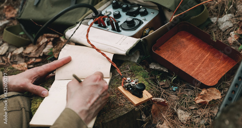 Obraz na płótnie Russian Soviet Infantry Red Army Soldier In World War II using Russian Soviet Portable Radio Transceiver In Trench Entrenchment In Spring Autumn Forest. . Headphones And Telegraph Key. Close Up Hands, w salonie