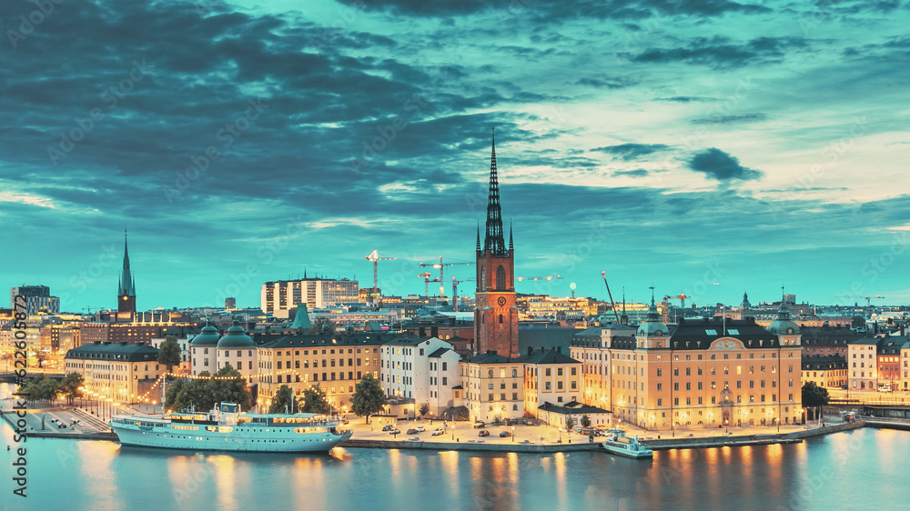 Stockholm, Sweden. Scenic View Of Stockholm Skyline At Summer Evening. Famous Popular Destination Scenic Place In Dusk Lights. Riddarholm Church Day To Night Transition