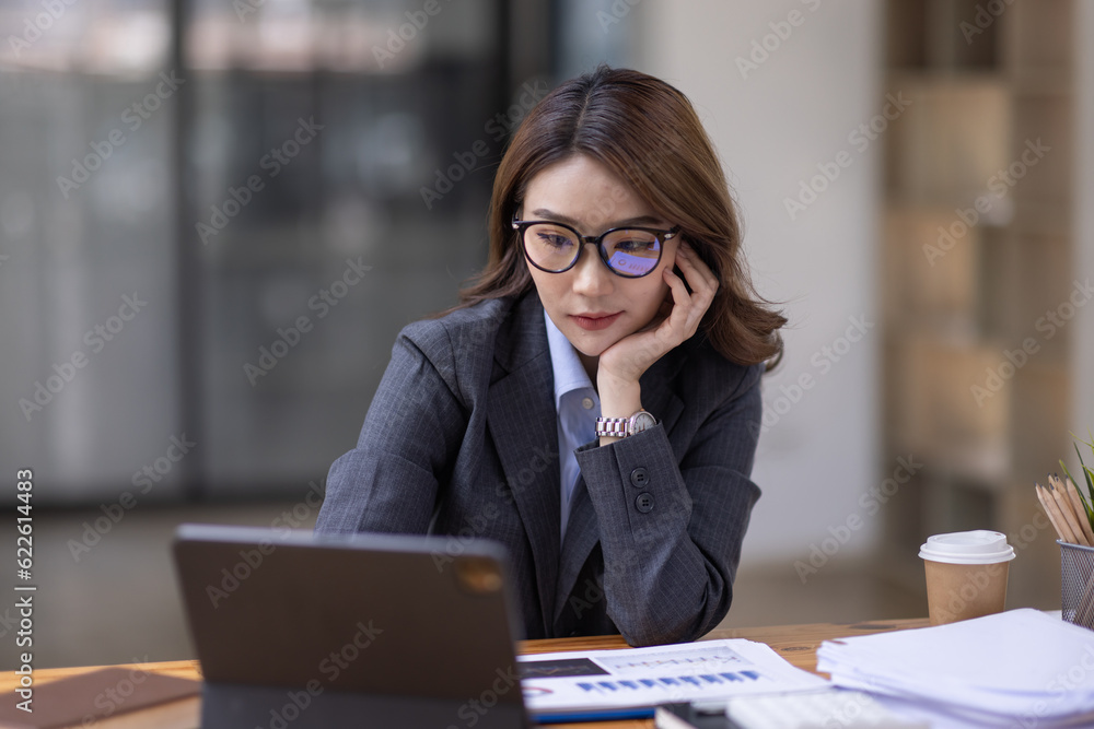 Asian Business woman using calculator and laptop for doing math finance on an office desk, tax, report, accounting, statistics, and analytical research concept
Asian Business woman using calculator and laptop for doing math finance on an office desk, tax, report, accounting, statistics, and analytical research concept