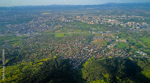 Panoramic view of Sofia, the capital of Bulgaria from a height from a drone. At the foot of Vitosha Mountain in early spring the whole forest is green