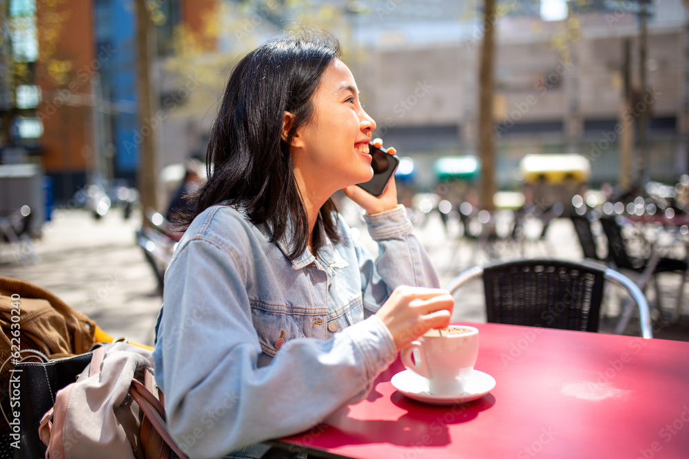 smiling young woman sitting at cafe talking with mobile phone smiling young woman sitting at cafe talking with mobile phone