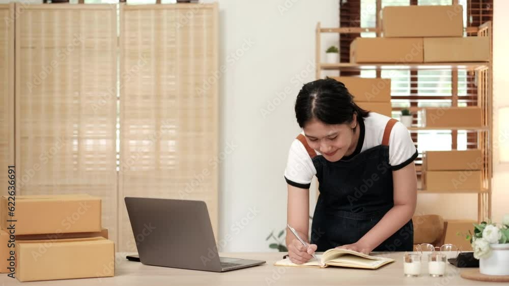 Startup small business SME, Entrepreneur owner woman using laptop taking receive and checking online purchase shopping order to preparing pack product box Startup small business SME, Entrepreneur owner woman using laptop taking receive and checking online purchase shopping order to preparing pack product box