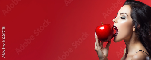 Beautiful young woman holding a red apple - symbolic of sin and temptation banner photo