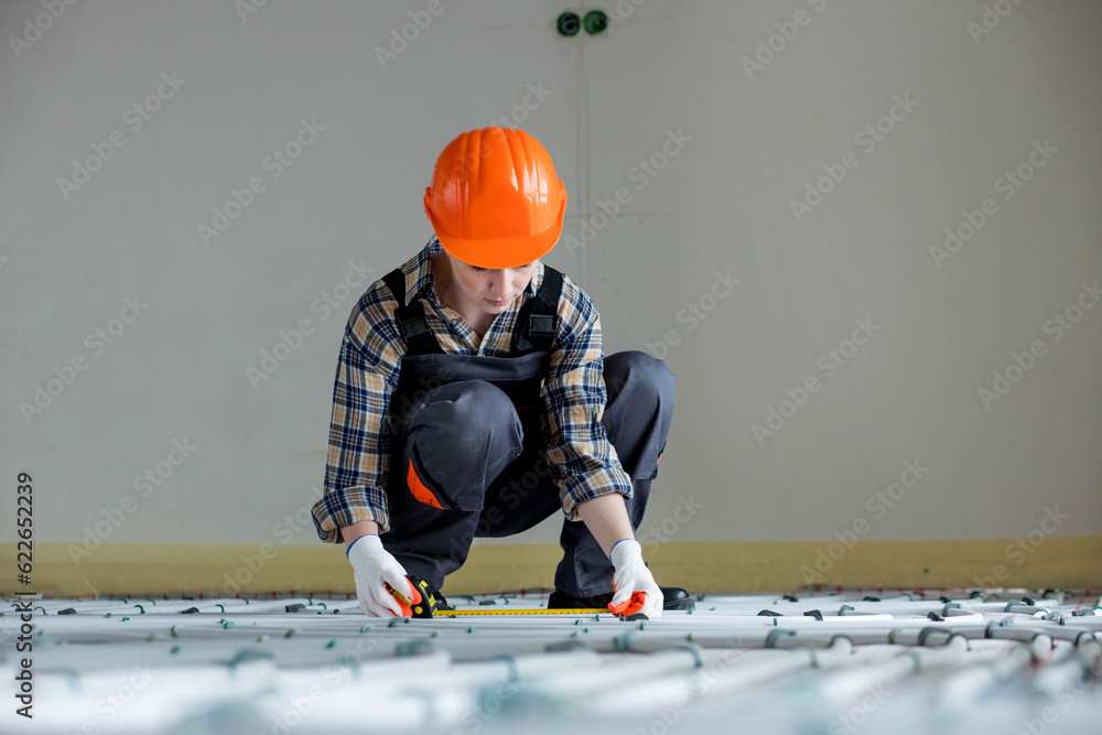 Worker is installing underfloor heating system. Warm floor heating system Worker is installing underfloor heating system. Warm floor heating system