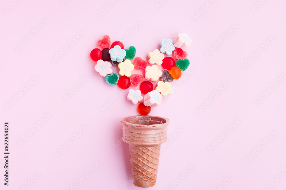 Multicolored Marshmallows and jelly candy out of ice cream cone on pink background, Flower Shaped Marshmallows and jelly candy heart shaped Multicolored Marshmallows and jelly candy out of ice cream cone on pink background, Flower Shaped Marshmallows and jelly candy heart shaped