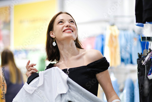 beautiful woman in a clothing store. Young woman shopping for clothes Free Download beautiful woman in a clothing store. Young woman shopping for clothes - GFXLoad
